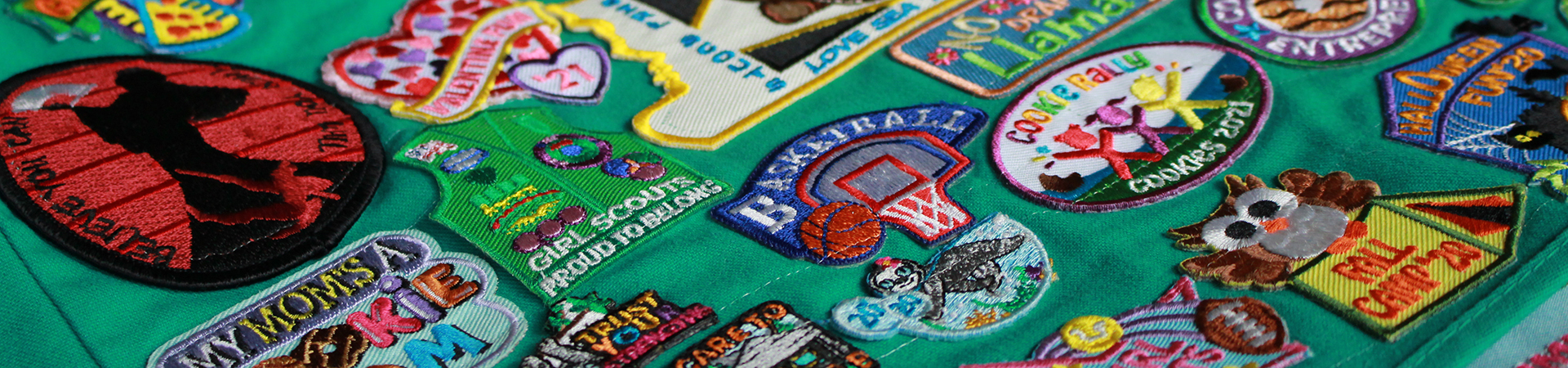  A Girl Scout Junior vest with many patches on it 