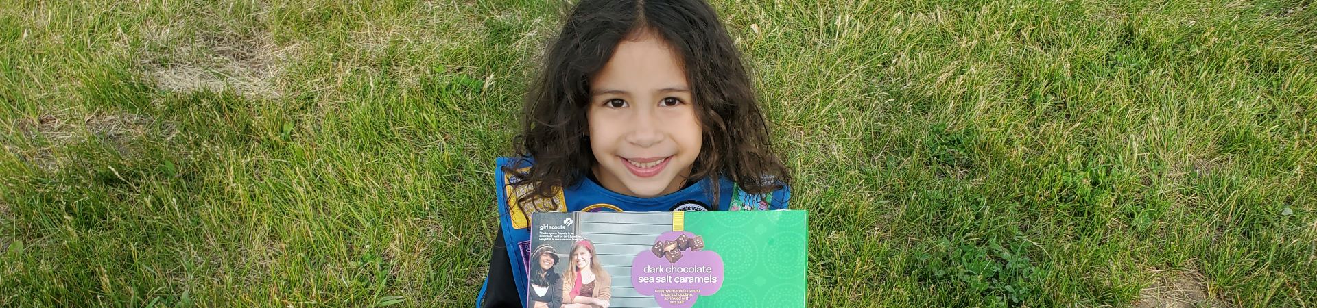  Girl Scout smiling and holding a box of candy 